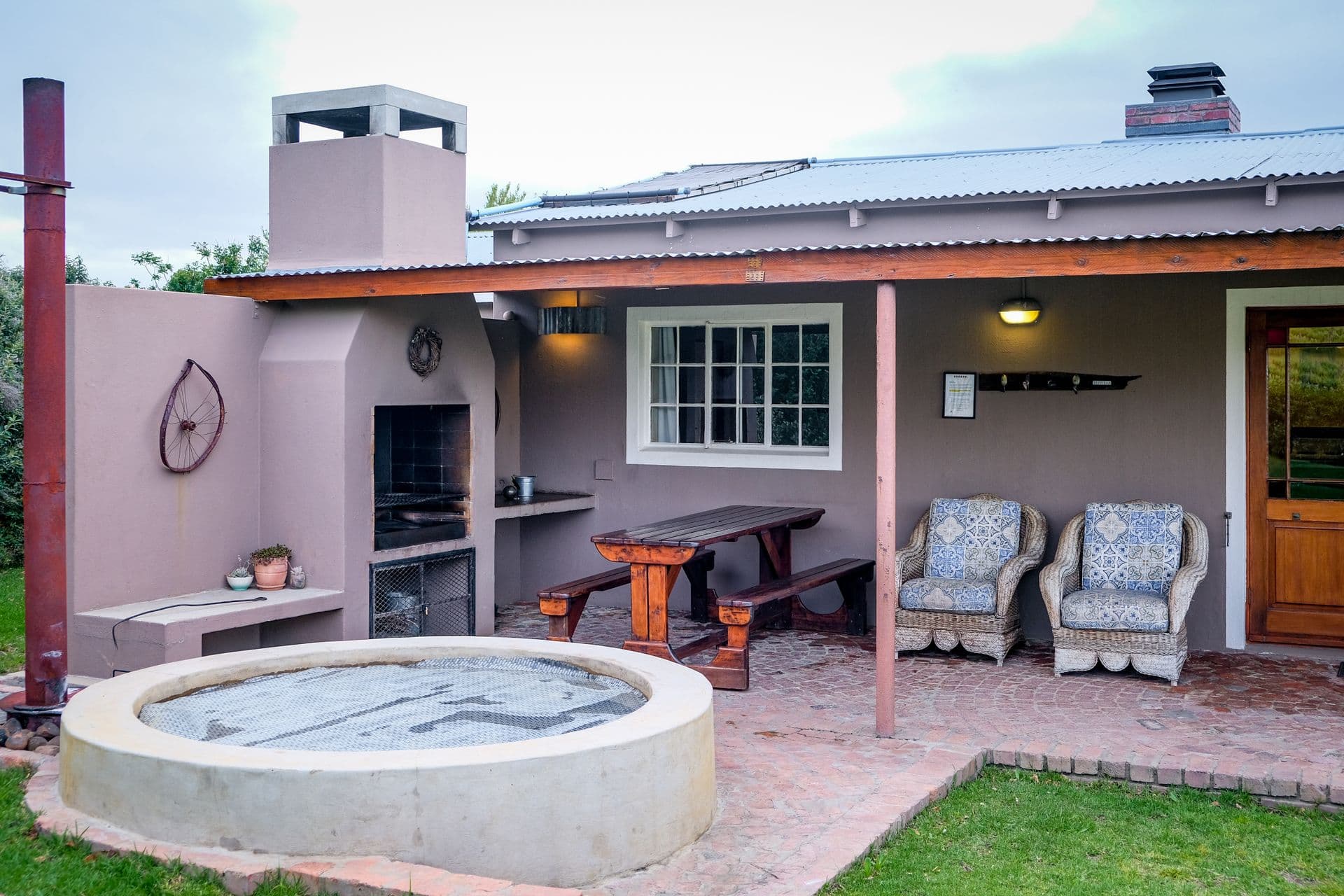 Covered hot tub set into a brick patio beside a covered outdoor seating area